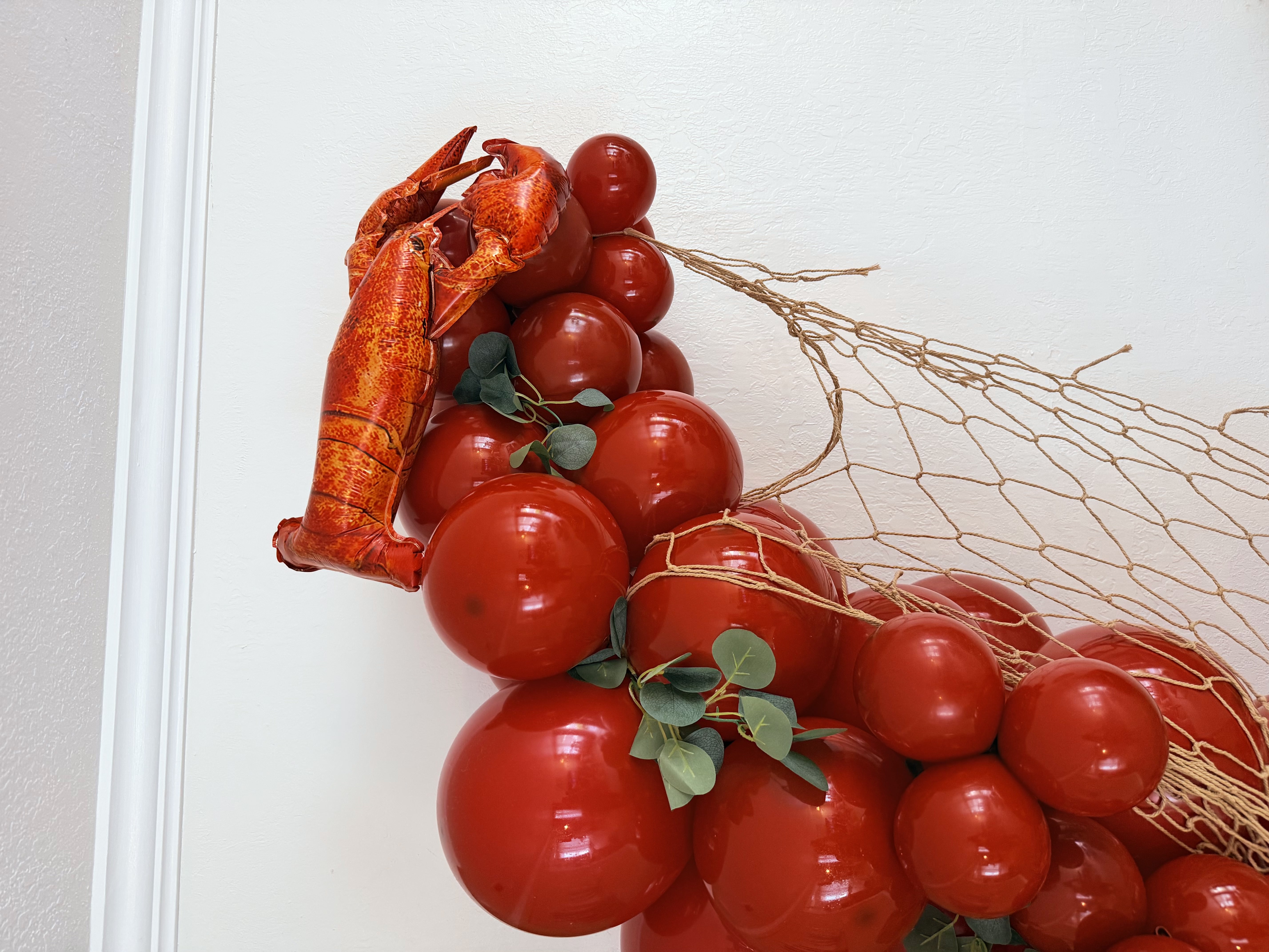Detail shot of lobster balloon garland with foliage accents