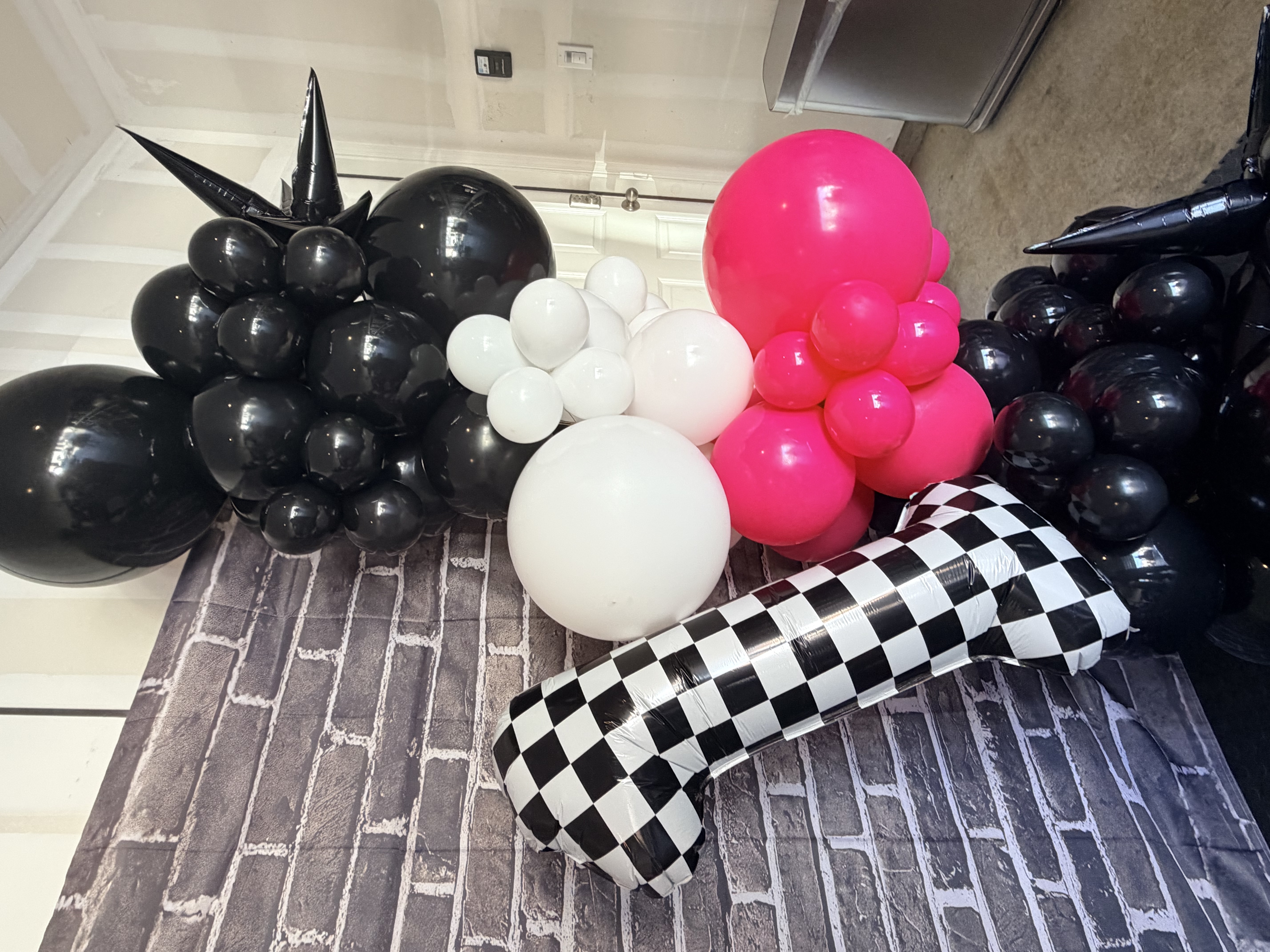 Close-up of race car themed balloon garland with checkered flag balloon