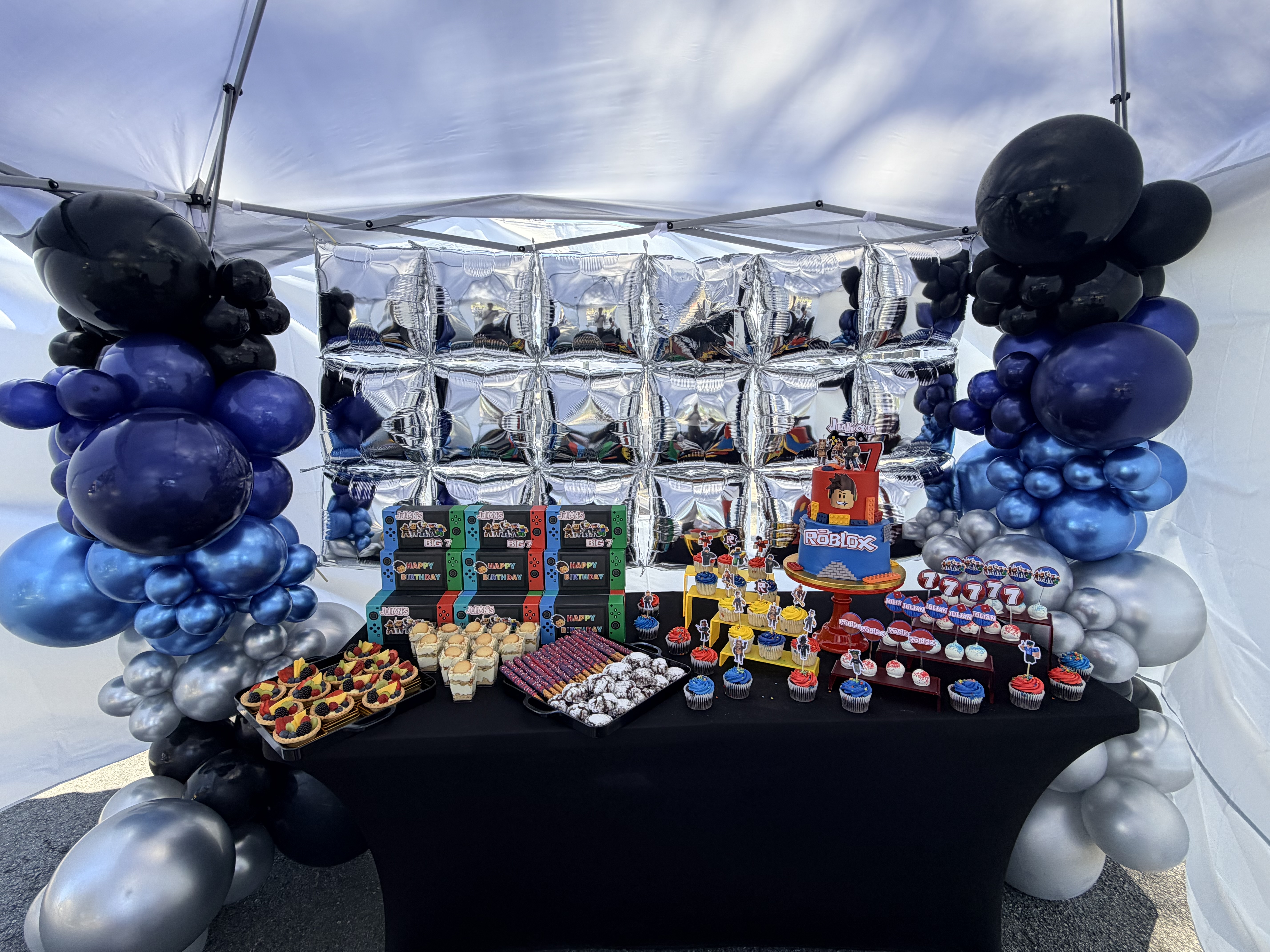 Roblox gaming themed dessert table with balloon columns